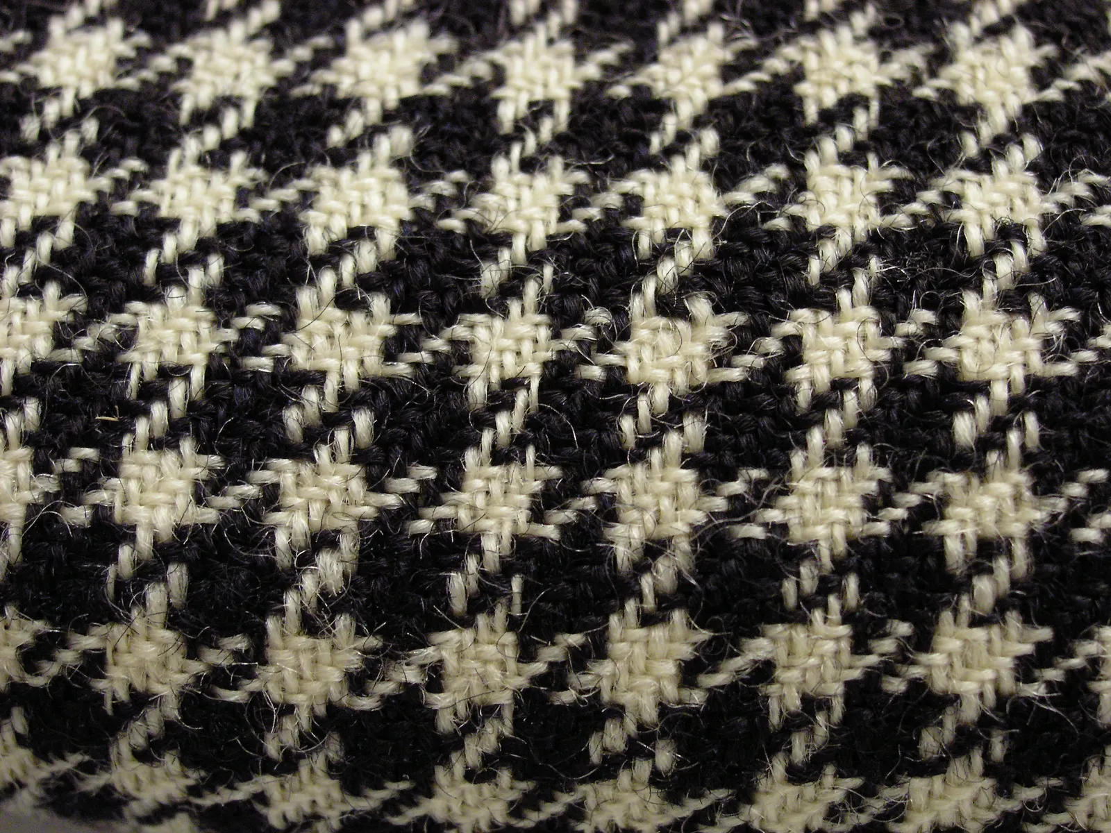 Close-up of a black and white wool houndstooth blanket, circa 1840, Auckland Museum 1931.509: checks with stepped teeth