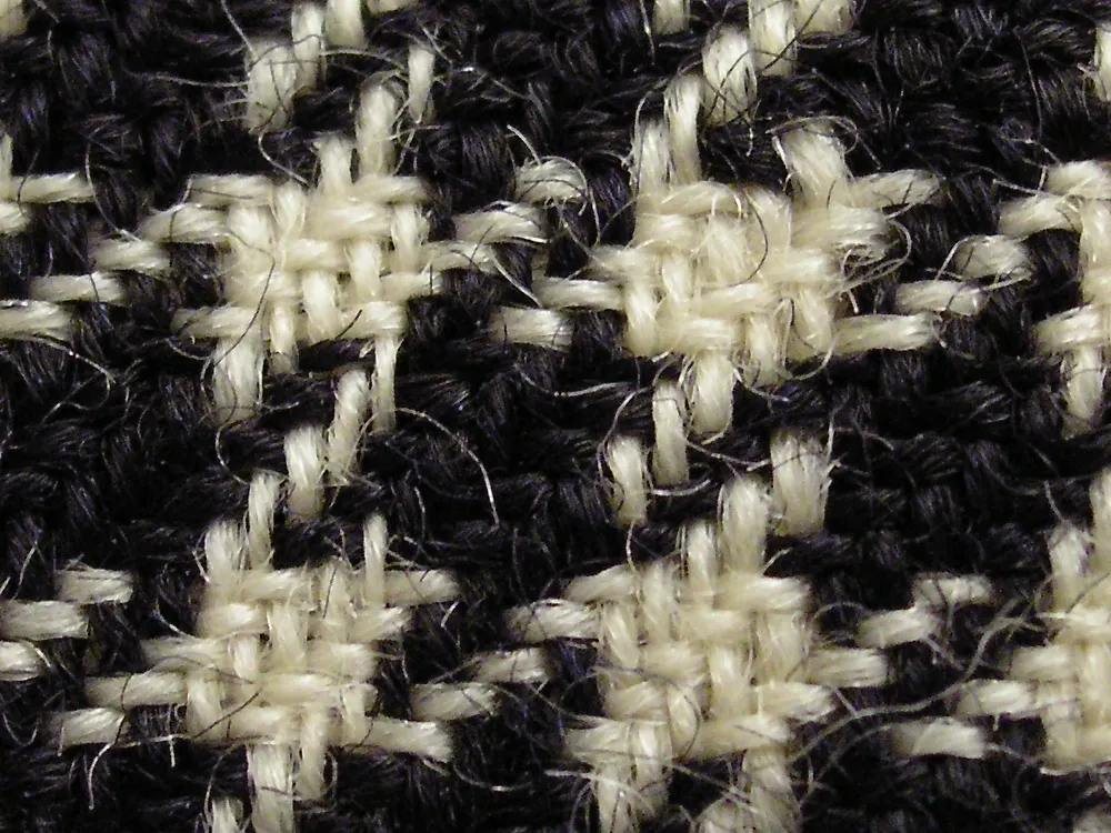 Detail of a black and white wool houndstooth blanket, circa 1840, Auckland Museum 1931.509: cream threads lying over black