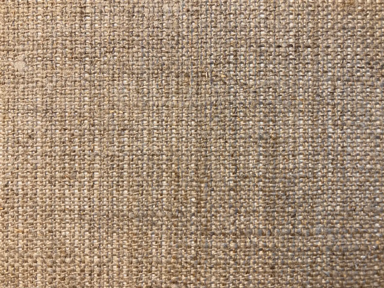 Beige cloth close up, uneven threads crossing over one, under one: plain weave in real yarn