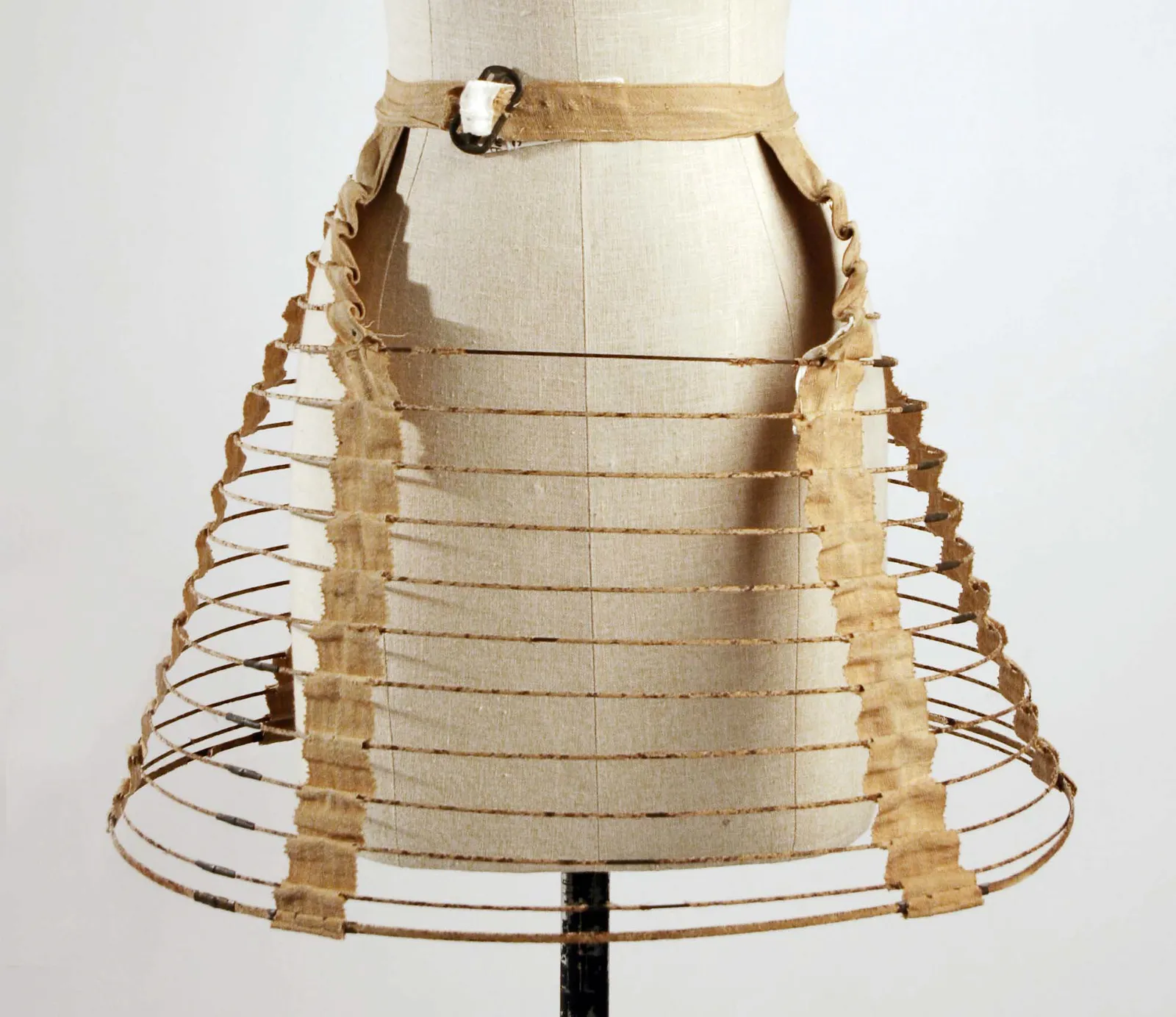Cage crinoline of steel hoops on cotton tapes hung from a buckled waistband; American, 1857; The Met C.I.53.72.15