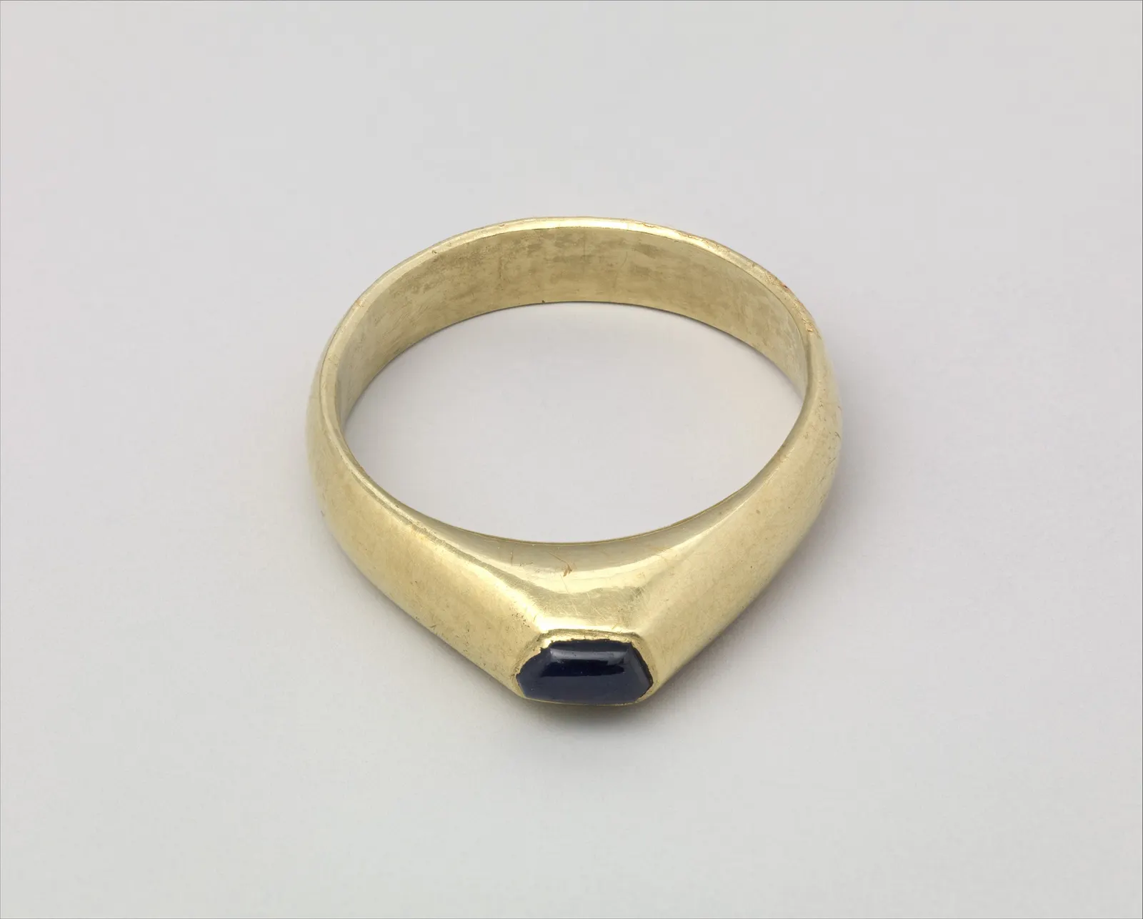 Gold stirrup ring, a smooth blue sapphire in a closed gold rim; British, late 13th or early 14th century; The Met 2015.697
