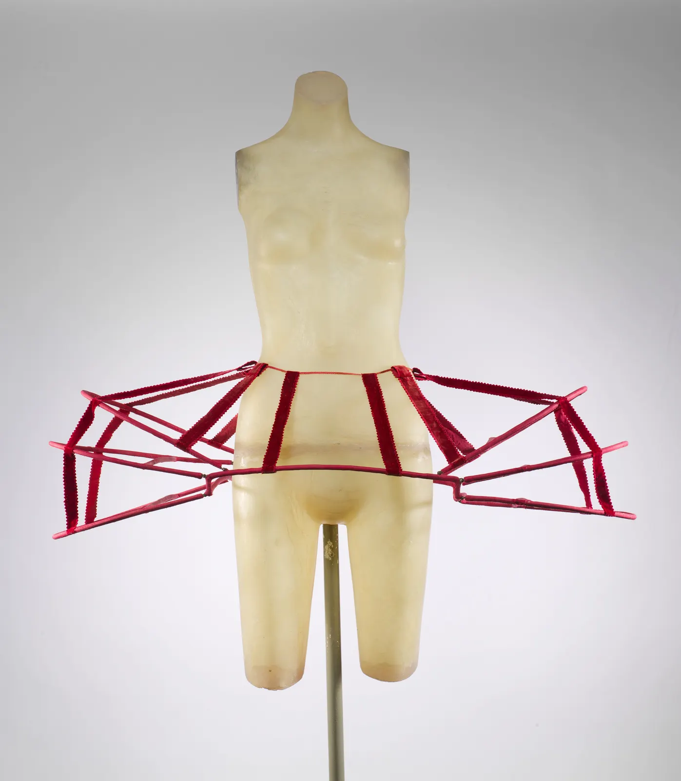 Pink silk-covered cane panniers with red ribbons standing out over the hips; French, late 18th century; The Met 2008.297a, b